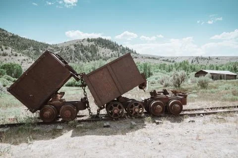 Old rusty mining ore carts on the tracks in the Bannack Ghost Town in Montana Stock Photos