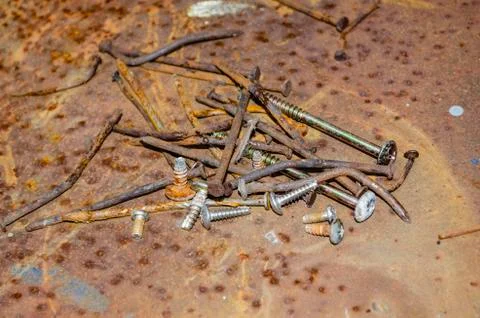Old rusty nails and screws on rusty background and texture Stock Photos