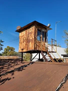 An old, rusty, non-working, abandoned metal guardhouse in a garages Photos