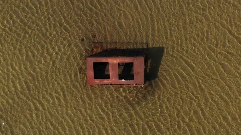 Old rusty object in the water in the middle of a top down drone shot Stock Footage 233168355