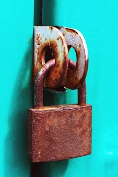 Old rusty padlock on a green door Stock Photos