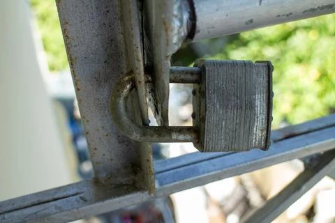 Old rusty padlock securing a metal structure outdoor Fotos de archivo