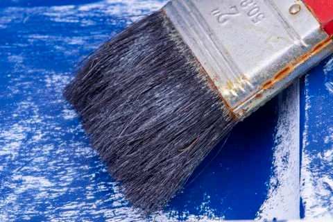Old rusty paintbrush in blue container with white paint Stock Photos