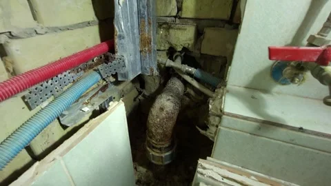 Old rusty plumbing system with pipes and valve exposed inside a wall during.. 動画素材 306732417