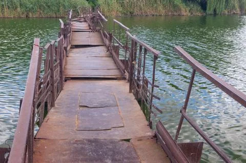 Old, rusty pontoon-bridge over small river Sura to remote Ukrainian village Stock Photos