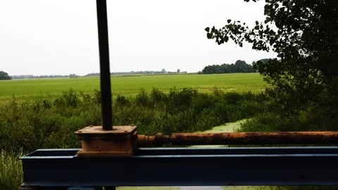 Old rusty reclamation system on small channel on agricultural field. Stock Footage 195194287