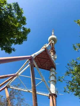 Old rusty red and white TV tower in Tbilisi against the background of blue sky Stock Photos