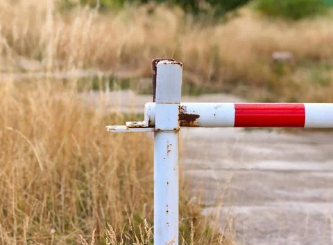 Old rusty red and white traffic barrier gate close up 库存照片