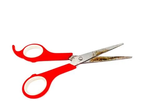 Old rusty red scissors isolated on white background. Used tool or Object Stock Photos