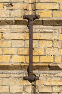 Old rusty ruined gate hinges on an old brick wall of the late 19th century Foto stock
