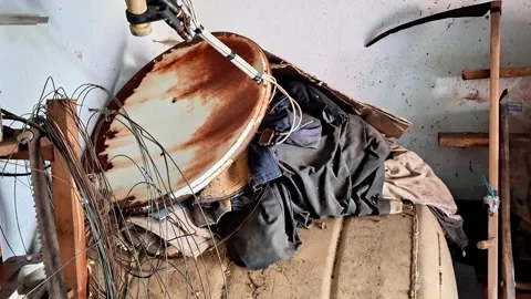 Old rusty satellite dish and junk in messy garage or workshop shed 動画素材 336525075