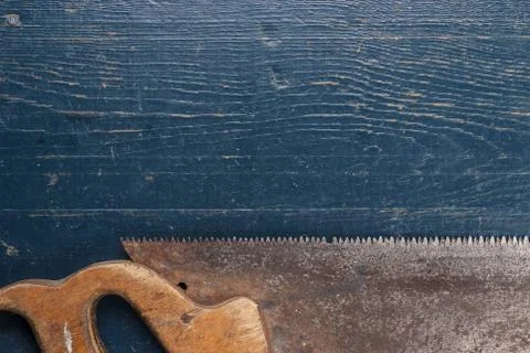 Old rusty saw on blue table Stock Photos