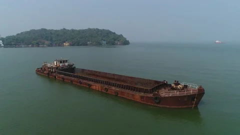 An old, rusty, semi-flooded barge in the sea near the island.  Aerial view. 스톡 동영상 85633790