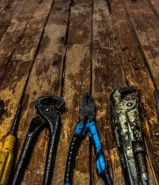 An old rusty set of hand tools on a wooden background. Stock Photos