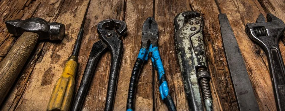 An old rusty set of hand tools on a wooden background. Stock Photos