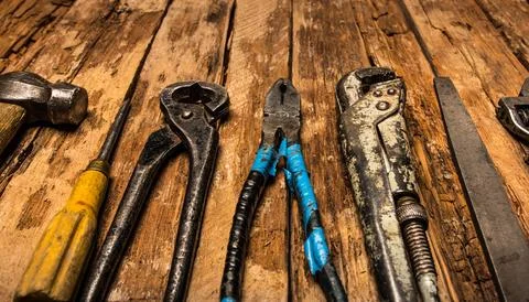 An old rusty set of hand tools on a wooden background. Stock Photos