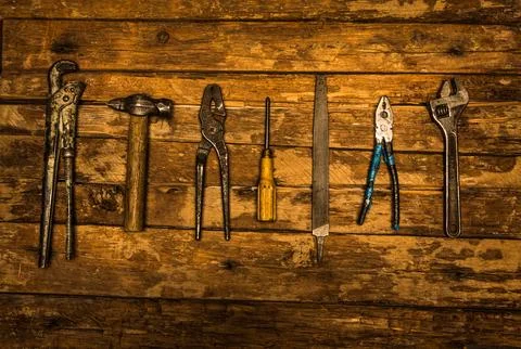 An old rusty set of hand tools on a wooden background. Stock Photos