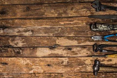 An old rusty set of hand tools on a wooden background. Stock Photos