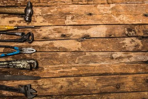 An old rusty set of hand tools on a wooden background. Stock Photos