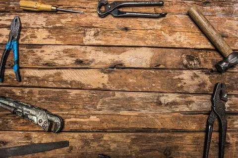 An old rusty set of hand tools on a wooden background. Stock Photos