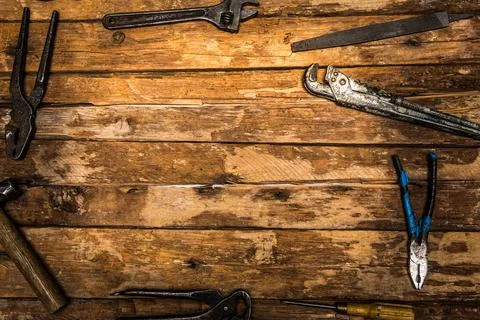 An old rusty set of hand tools on a wooden background. Stock Photos