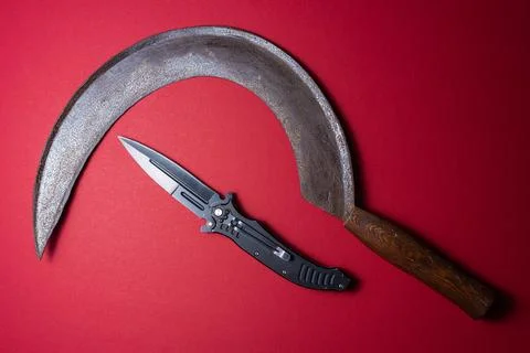 Old rusty sickle and modern folding knife Stock Photos