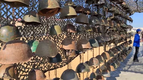 The old rusty soldier's helmets on the wall, one with bullet hole Stock Footage 152558888