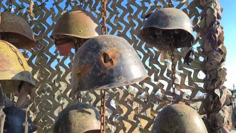The old rusty soldier's helmets on the wall, one with bullet hole Stock Footage 152558895