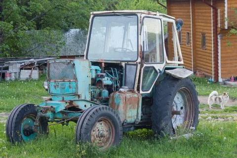 Old rusty soviet-made tractor in the farmyard. Transport Stock Photos
