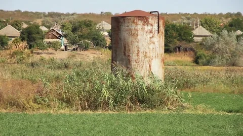 Old rusty Soviet water tank against the background of rural houses 스톡 동영상 262820536