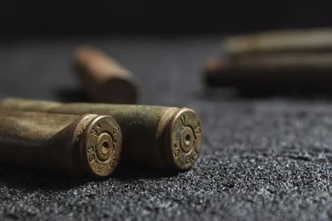 Old rusty spent shells on black concrete Stock Photos