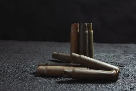 Old rusty spent shells on black concrete Stock Photos