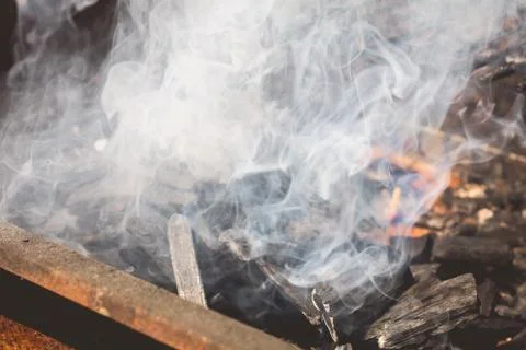 An old rusty steaming barbecue when lighting in garden Stock Photos