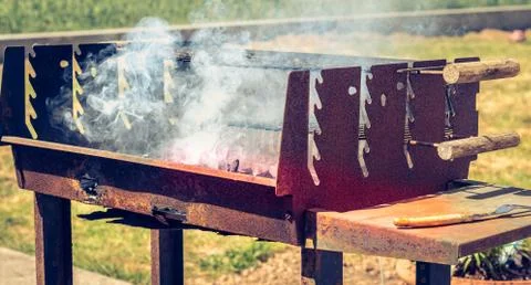 An old rusty steaming barbecue when lighting in garden Stock Photos
