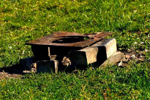 The old rusty stove stands on the bricks in the field. Homemade oven. Foto stock