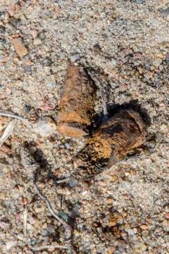 Old rusty submachine gun shells in the sand on the territory of the former sh Stock Photos