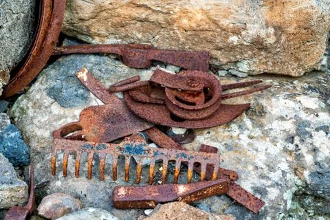 Old rusty tools for agricultural work: pickaxe, rake, pulley and hoe. Stock Photos