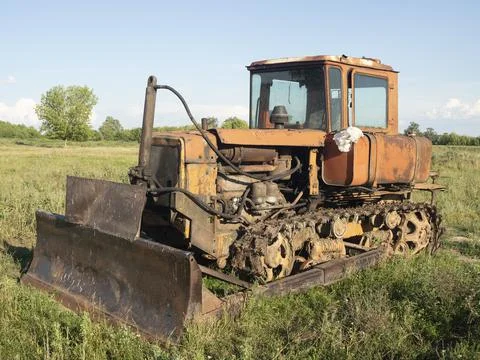 Old rusty tractor on tracks. Old farm equipment Stock Photos