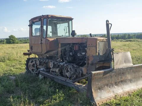 Old rusty tractor on tracks. Old farm equipment Stock Photos