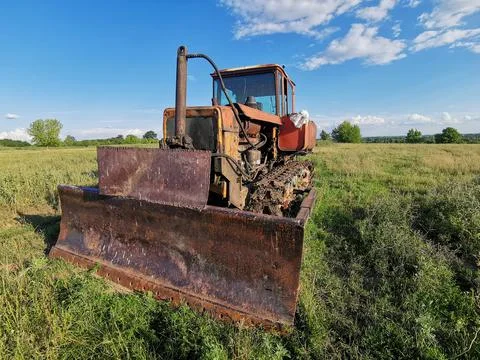 Old rusty tractor on tracks. Old farm equipment Stock Photos