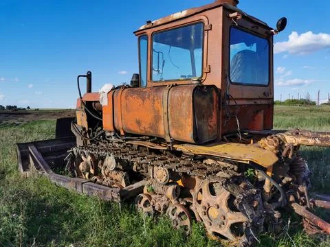 Old rusty tractor on tracks. Old farm equipment Stock Photos