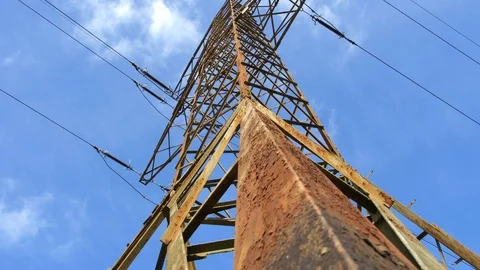 Old Rusty Transmission Tower and High Voltage Power Lines on Blue Sky Background Stock Footage 107423473