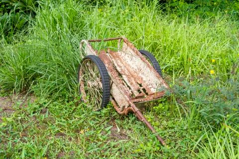 Old rusty trolley is in the grass forest. Stock Photos
