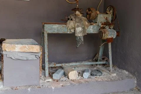 Old rusty turning lathe machine for manufacturing stone products in a workshop Stock Photos