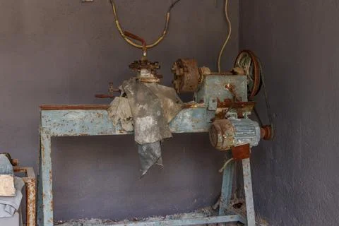 Old rusty turning lathe machine for manufacturing stone products in a workshop Stockfoto's