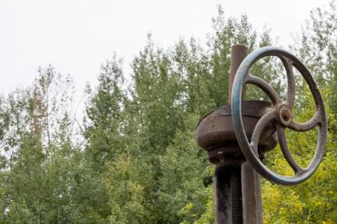 Old rusty valve close up on greenery background. Stock Photos