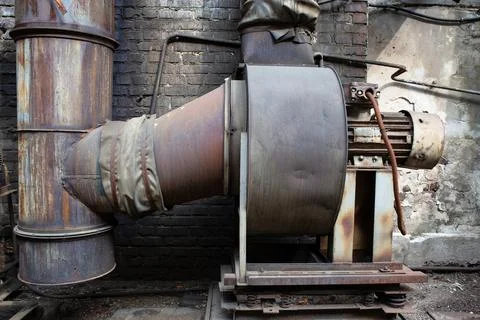 An old rusty ventilation unit in an abandoned metal processing plant. Black s Stock Photos