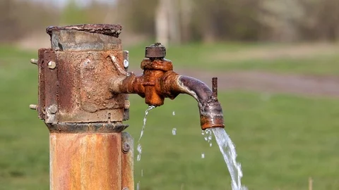 An old rusty water column against a green grass background. Stock Footage 130169290