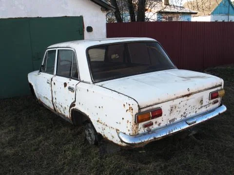 Old rusty white car without wheels outdoor Stock Photos
