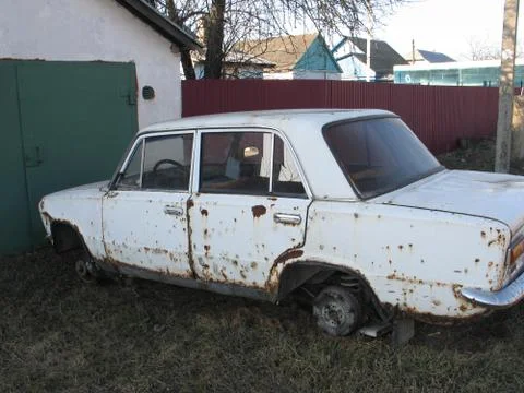 Old rusty white car without wheels outdoor Foto stock